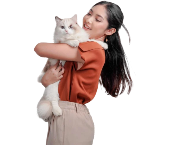 Femme souriante tenant un chat Ragdoll blanc et beige dans ses bras.