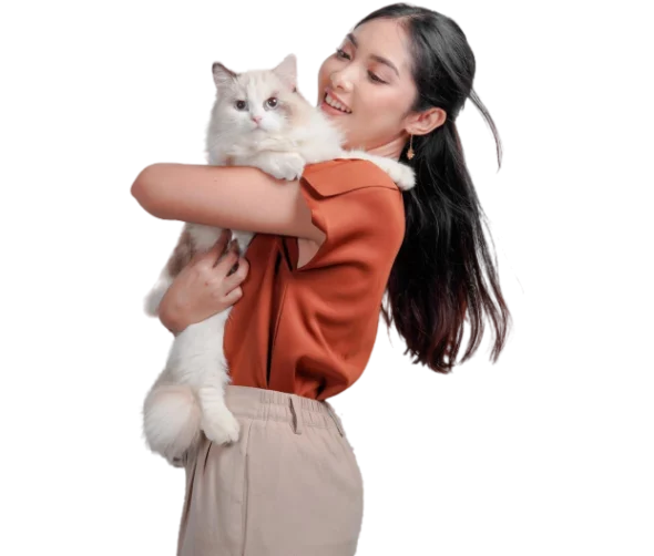 Femme souriante tenant un chat Ragdoll blanc et beige dans ses bras.